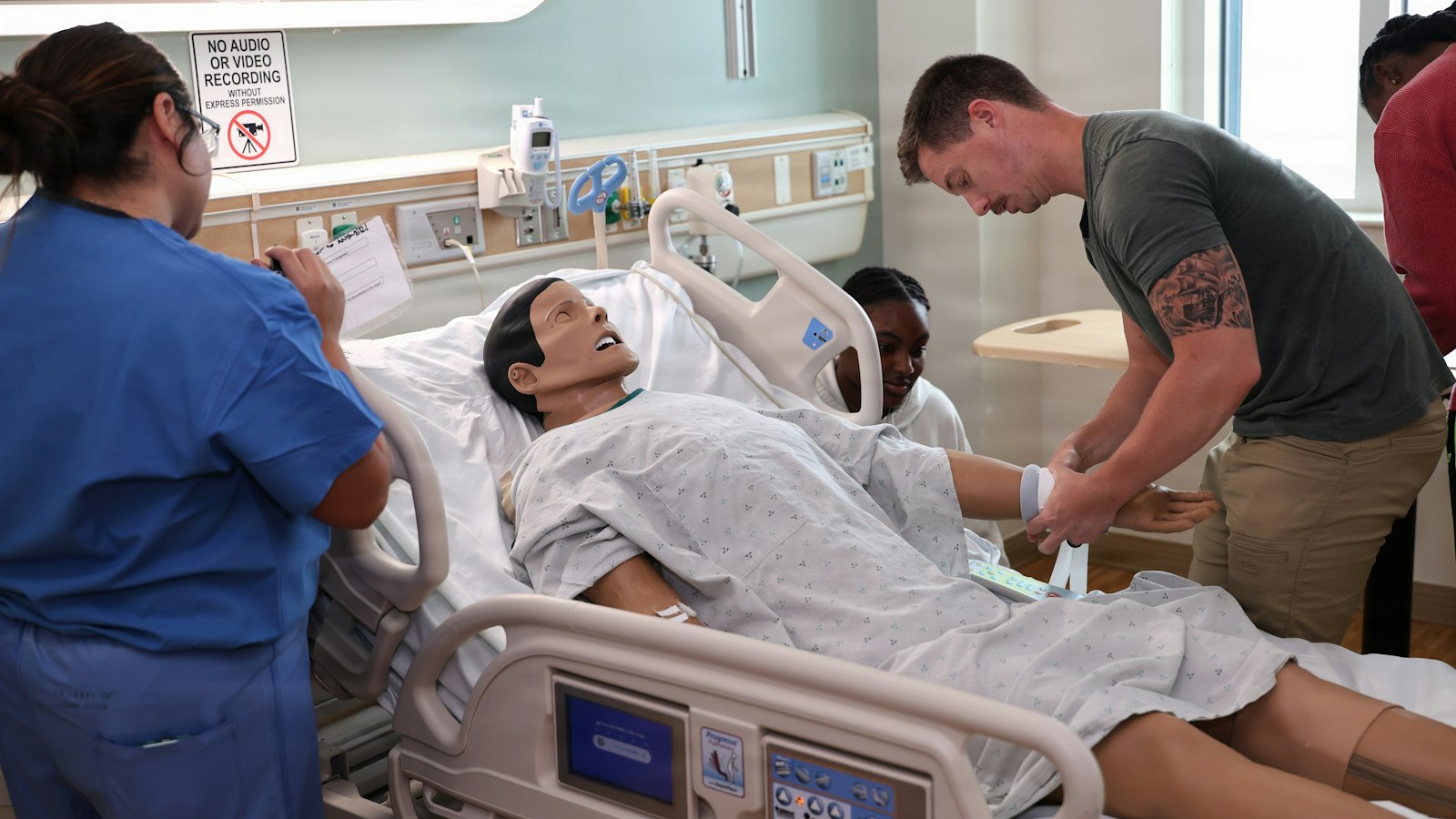 Medical students practising on a manikin in a simulation room